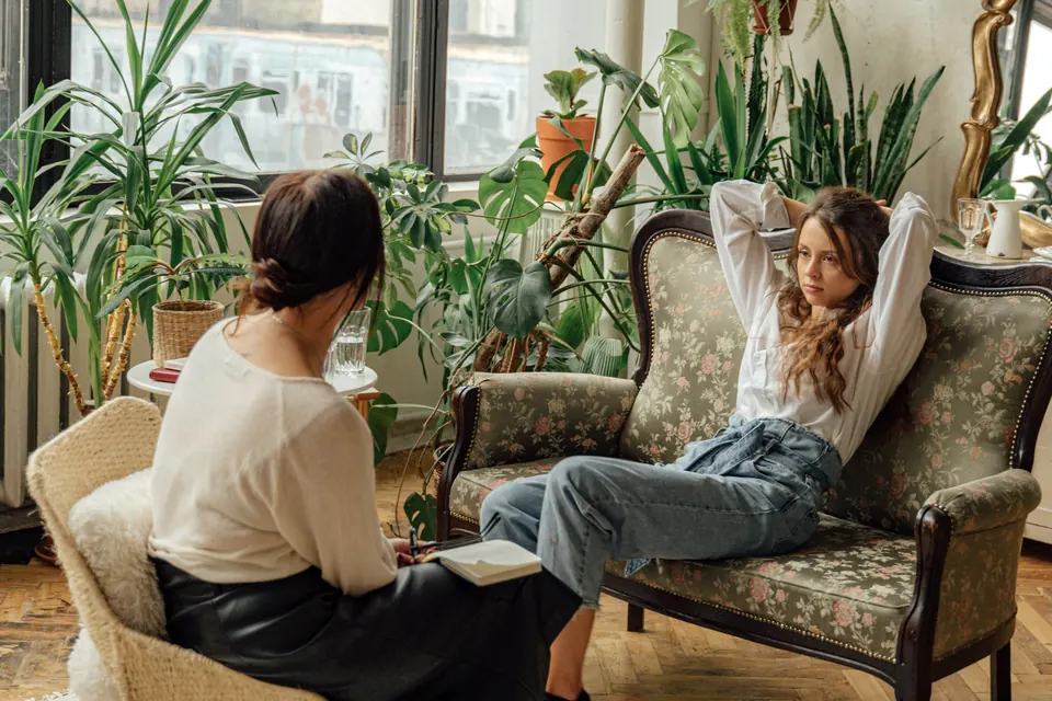 Twee vrouwen in gesprek in een kamer vol planten